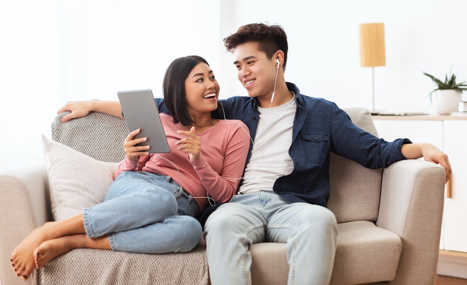 japanese-spouses-using-tablet-browsing-internet-sitting-on-couch-indoor.jpg